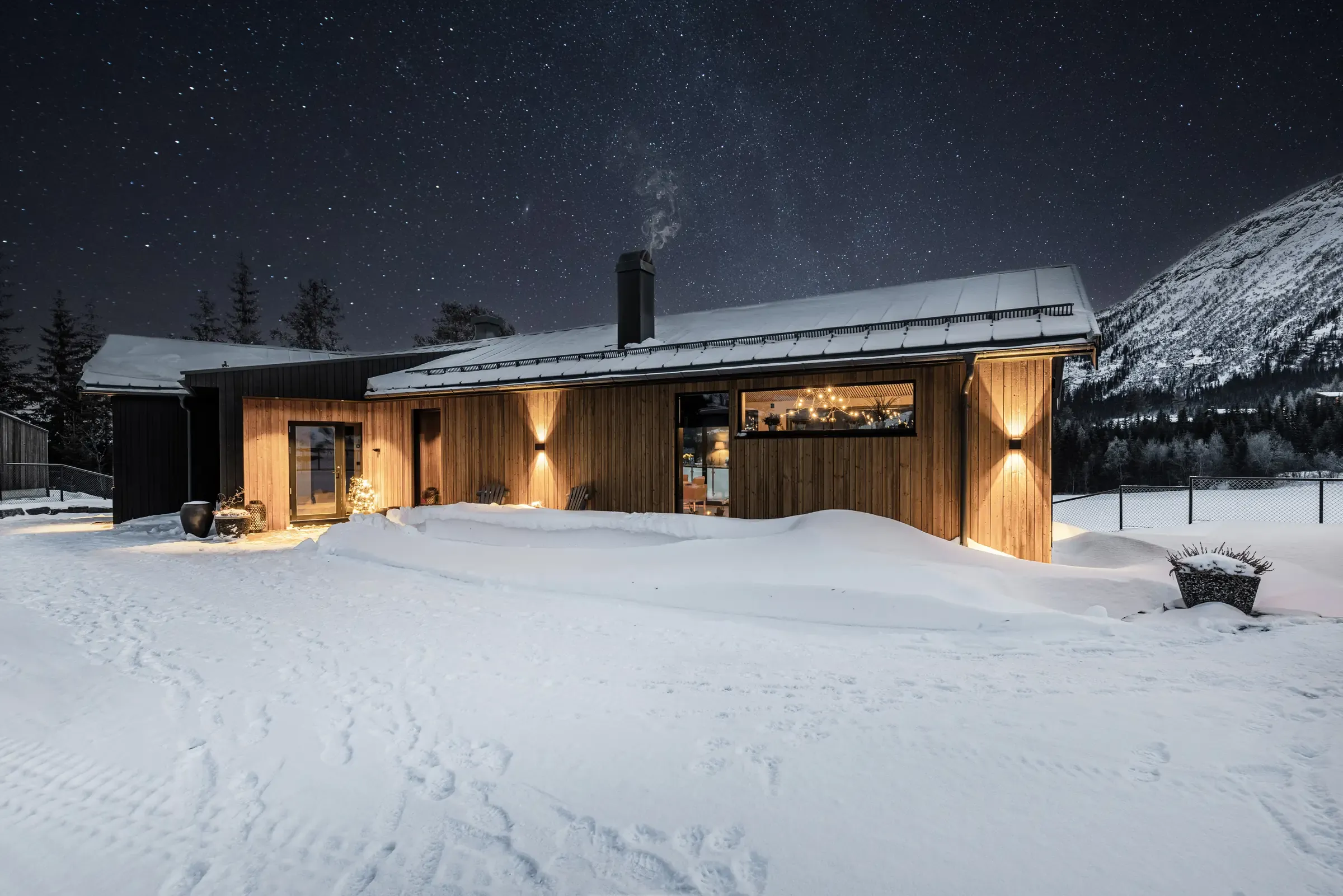 New house in Hemsedal centre on a winter evening, with starry sky and mountains
