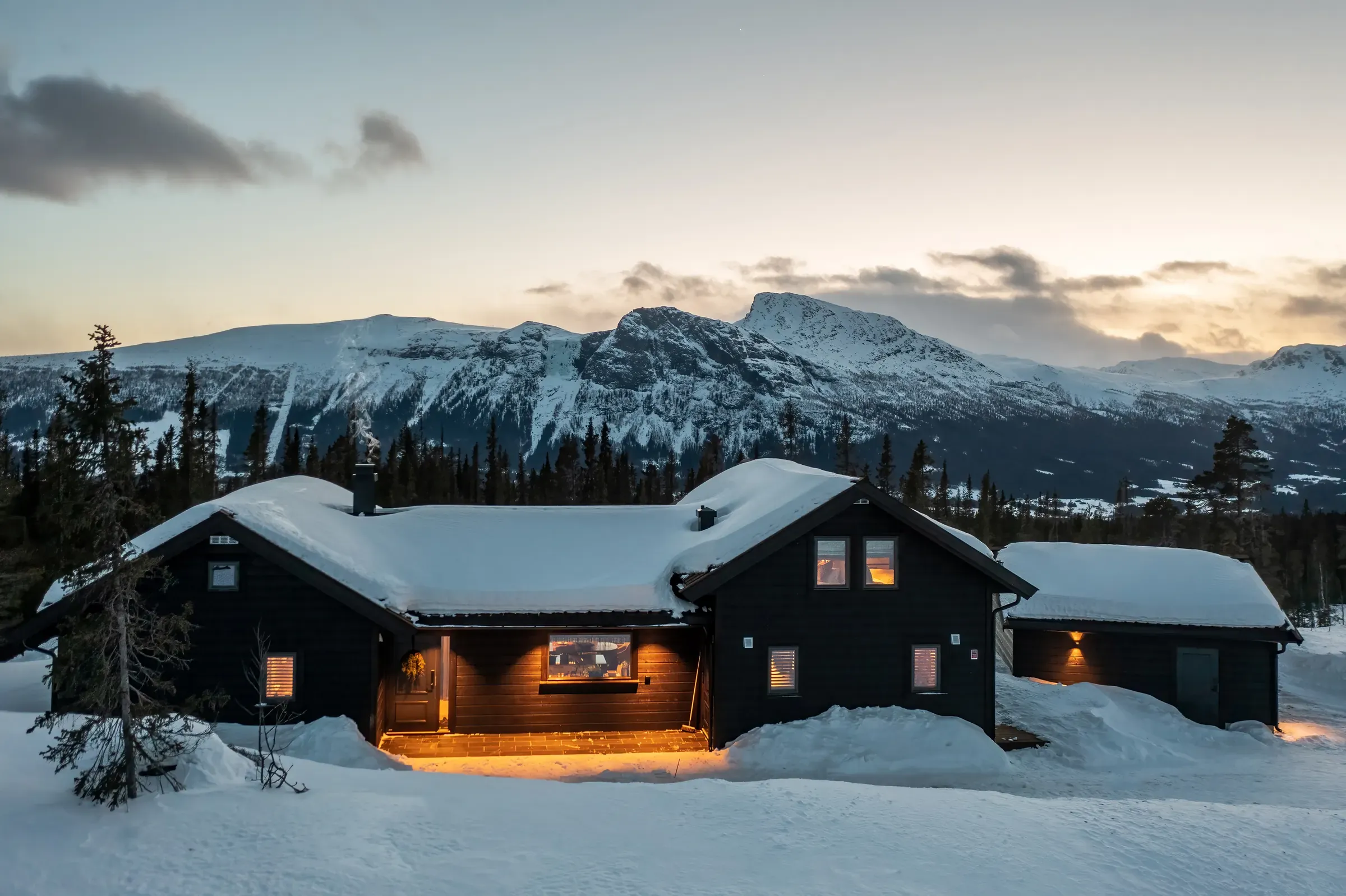 Cabin at Lykkja in Hemsedal on a winter evening, with the mountains behind