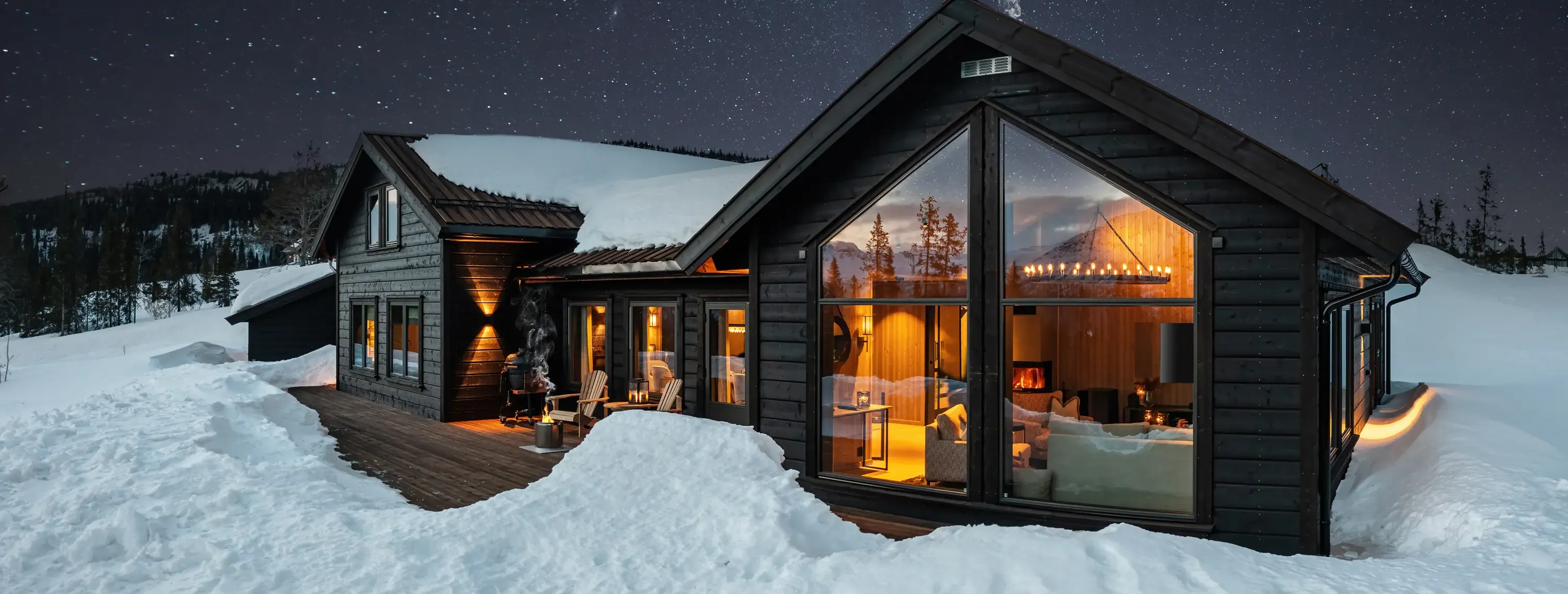 New cabin at Lykkja in Hemsedal on a starry winter evening, with a lit glass gable