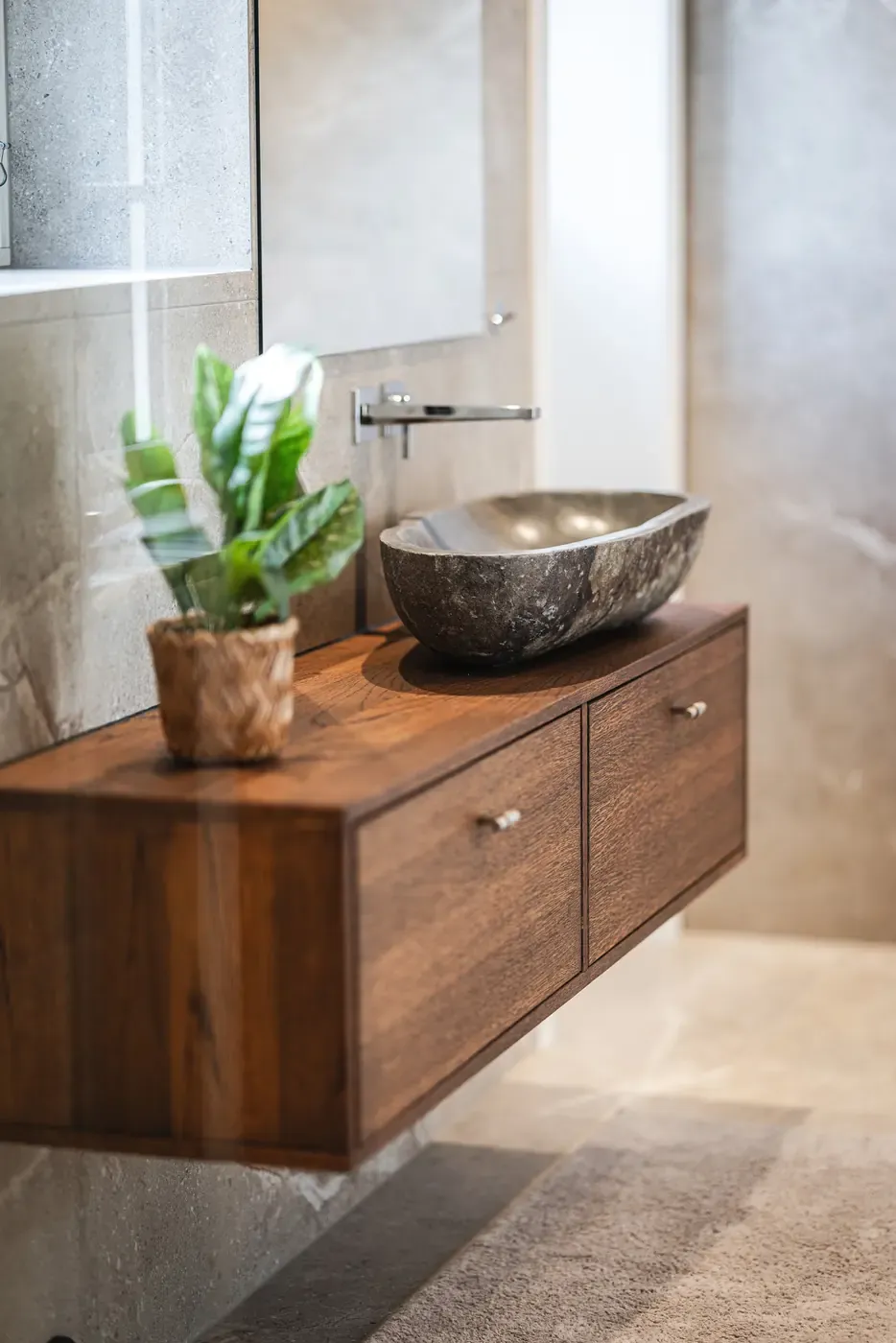 Stone washbasin on a wall-hung wooden vanity